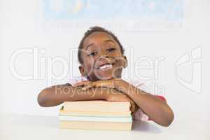 Portrait of smiling girl with books in classroom
