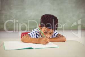 Boy doing homework in classroom