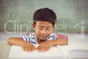 School boy memorizing the lesson in classroom