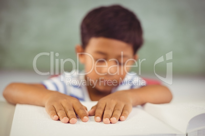 School boy memorizing the lesson in classroom