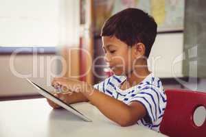 Schoolboy using digital tablet in classroom