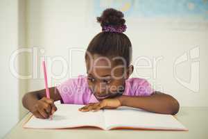 School girl doing homework in classroom