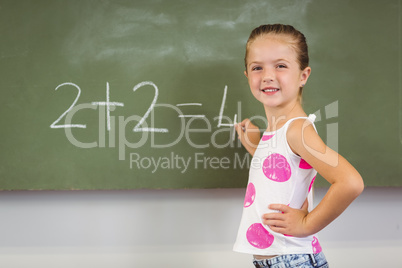 Schoolgirl doing mathematics on chalkboard in classroom