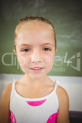 Portrait of happy schoolgirl smiling in classroom