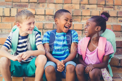 Happy school kids sitting together on staircase