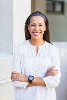 Portrait of smiling school teacher standing with arms crossed