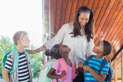 Smiling teacher and kids talking with each other