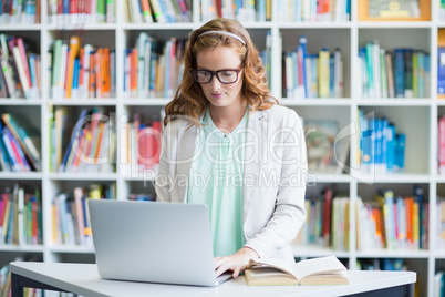 Teacher using laptop in library