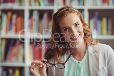 Portrait of smiling school teacher in library