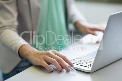 Teacher using laptop in library