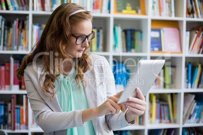 Teacher using digital tablet in library