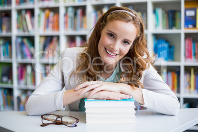 Portrait of smiling school teacher with books in library