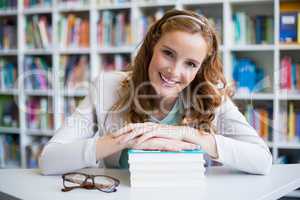 Portrait of smiling school teacher with books in library