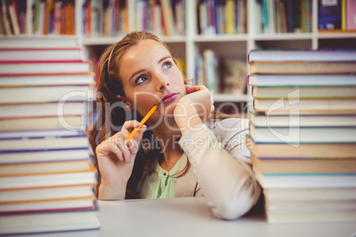 Thoughtful school teacher with books in library