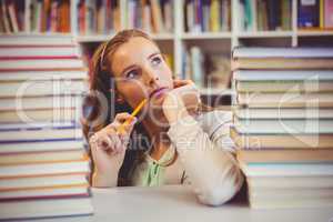 Thoughtful school teacher with books in library