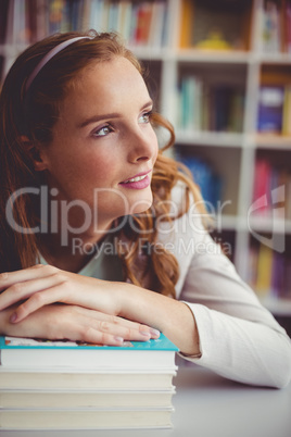 Thoughtful school teacher with books in library