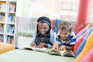 School kids lying on sofa and reading book