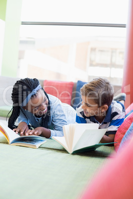 School kids lying on sofa and reading book