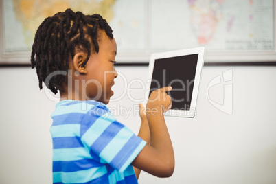 School boy using a digital tablet in classroom