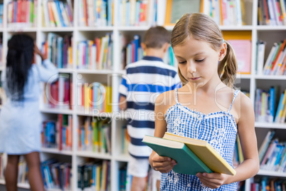 Girl looking at a book in library