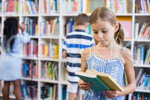 Girl looking at a book in library