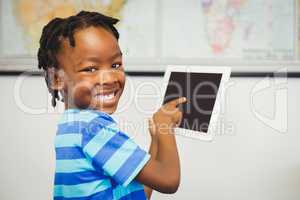 Portrait of school boy using a digital tablet in classroom