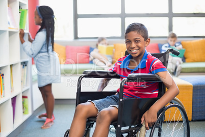 Portrait of disabled schoolboy on wheelchair in library Portrait of disabled schoolboy on wheelchair in library