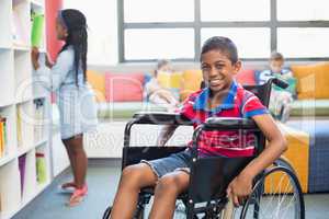 Portrait of disabled schoolboy on wheelchair in library