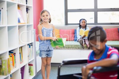 Girl holding a book in library