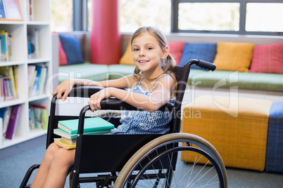 Disabled school girl with books in library