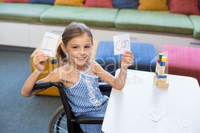 Disabled girl holding placard that reads I Can in library