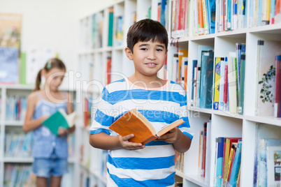 Boy holding a book in library