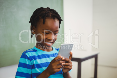 Schoolboy using mobile phone in classroom