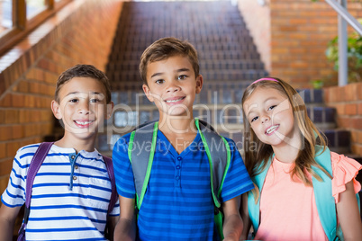 Portrait of smiling school kids standing together on staircase