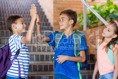 School kids giving high five on staircase