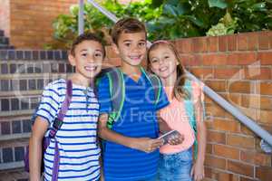 Portrait of smiling school kids standing on school staircase