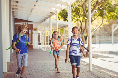 Happy school kids running in corridor