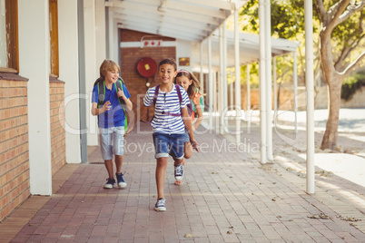 Happy school kids running in corridor