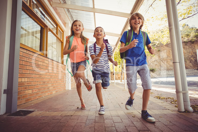 Happy school kids running in corridor