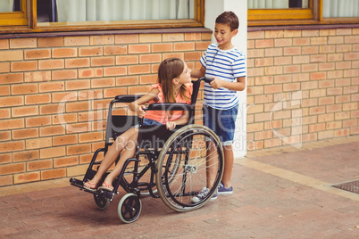 Schoolboy talking to a girl on wheelchair