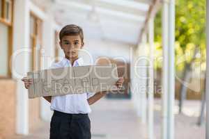 Schoolboy holding placard which reads please help