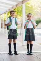 Smiling school kids standing in corridor