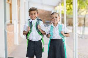 Smiling school kids standing in corridor