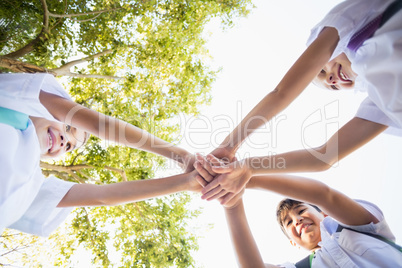 School kids stacking hands in campus