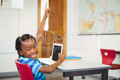 Happy schoolboy with digital tablet in classroom