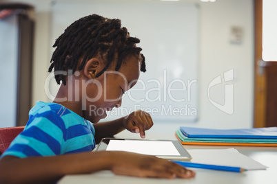 Schoolboy using digital tablet in classroom