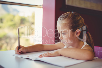 Girl doing homework in classroom