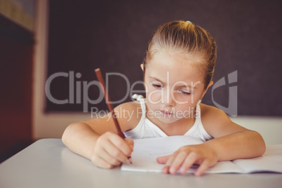 Girl doing homework in classroom