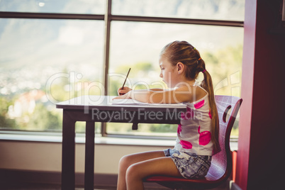 Girl doing homework in classroom