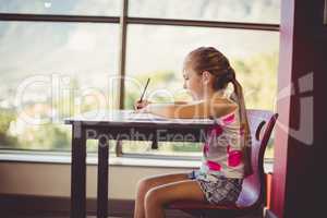 Girl doing homework in classroom